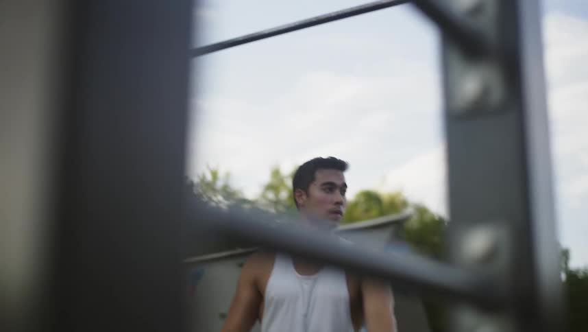 A man doing pull ups at a playground
