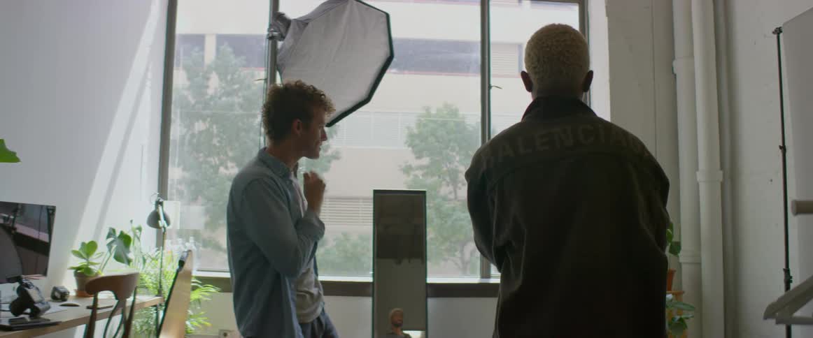 Two men talk in a photography studio
