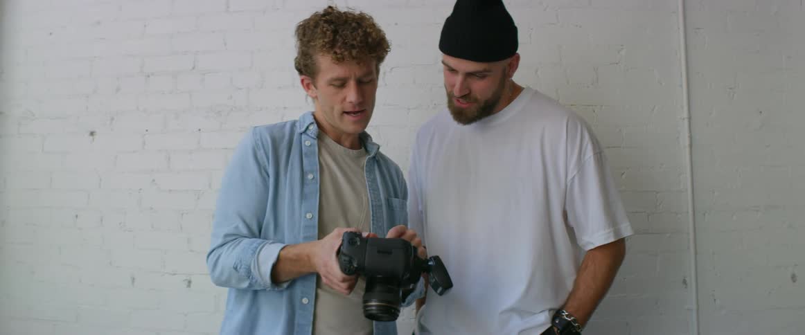 A man shows his camera to another man