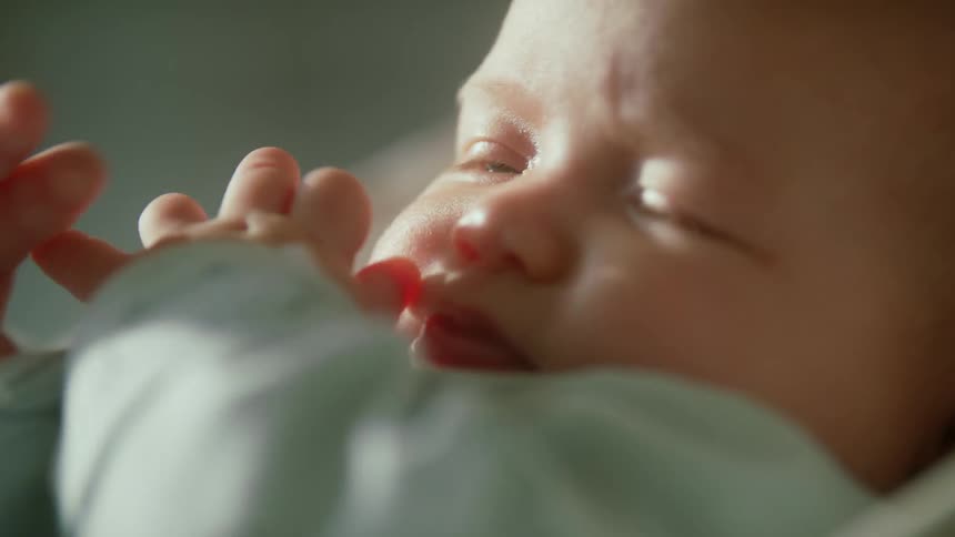 Person wipes cloth across baby