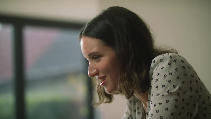 A woman in a room with a wall and door in the background