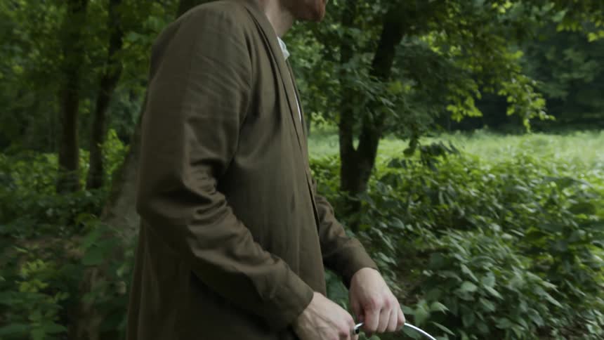 A man carries a bucket of water in a forest area