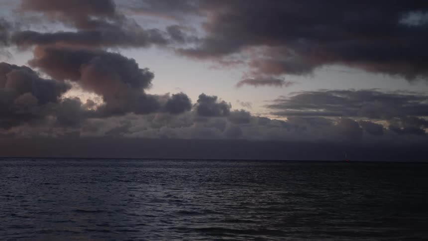 Water ripples and moves under a dark cloudy sky