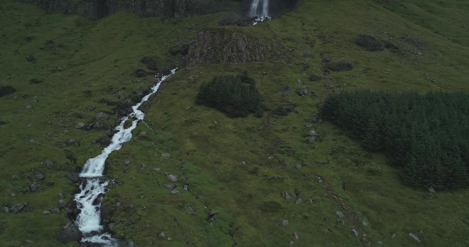 A waterfall is falling into streams down the mountain