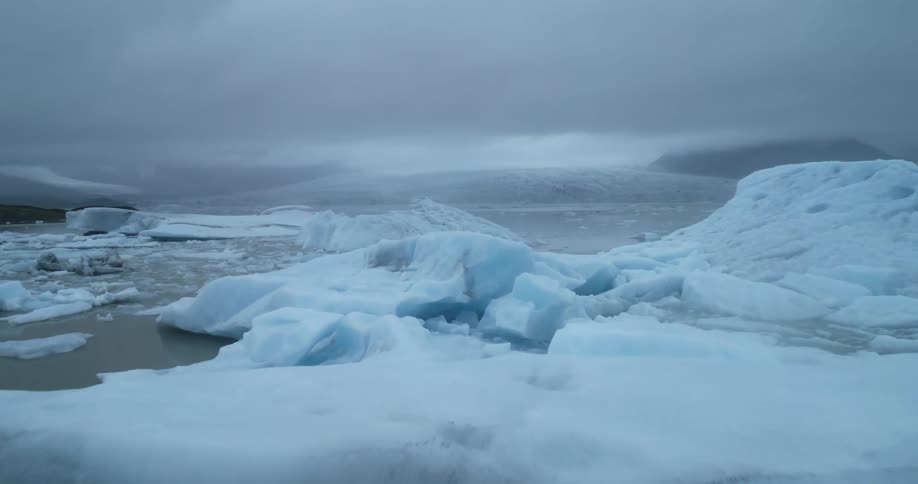 Broken ice caps fill a murky ocean
