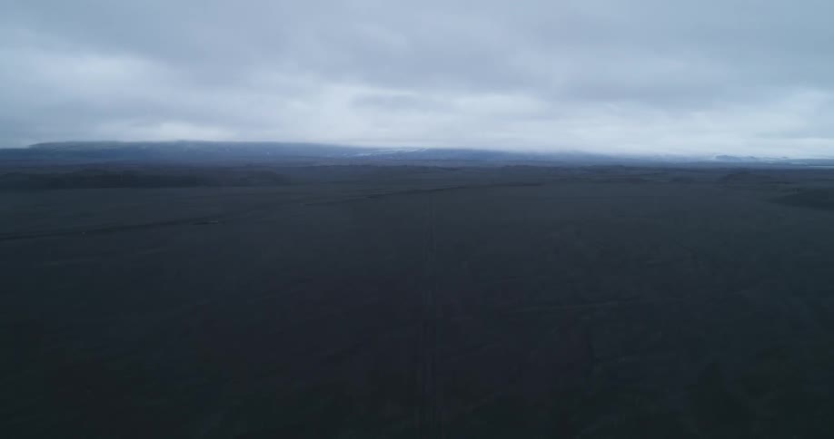 Fog covers terrain stretching to mountains on horizon on overcast day