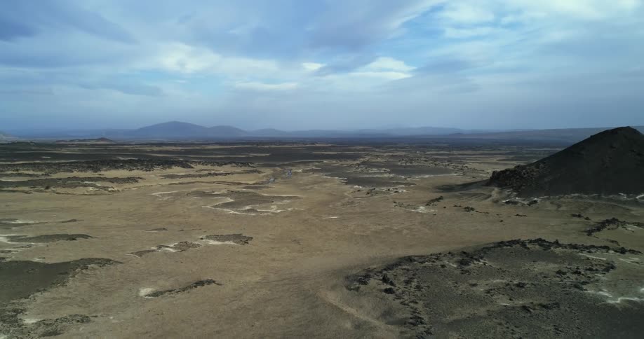 An aerial view of a desert with some hills in it