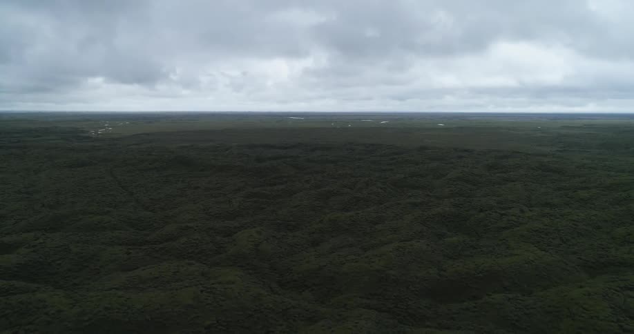 Green hills under a cloudy gray sky