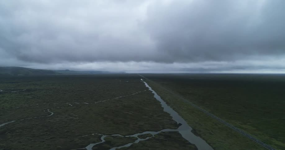 Vehicles travel down the highway by the empty fields