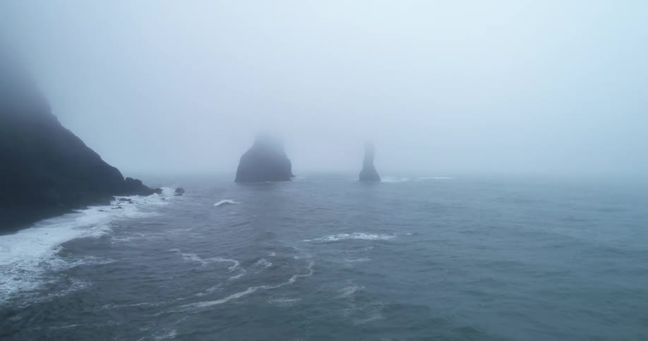 Heavy fog covers the mountain shore