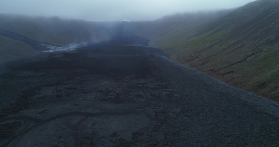A stream of lava rock is drying and giving off smoke