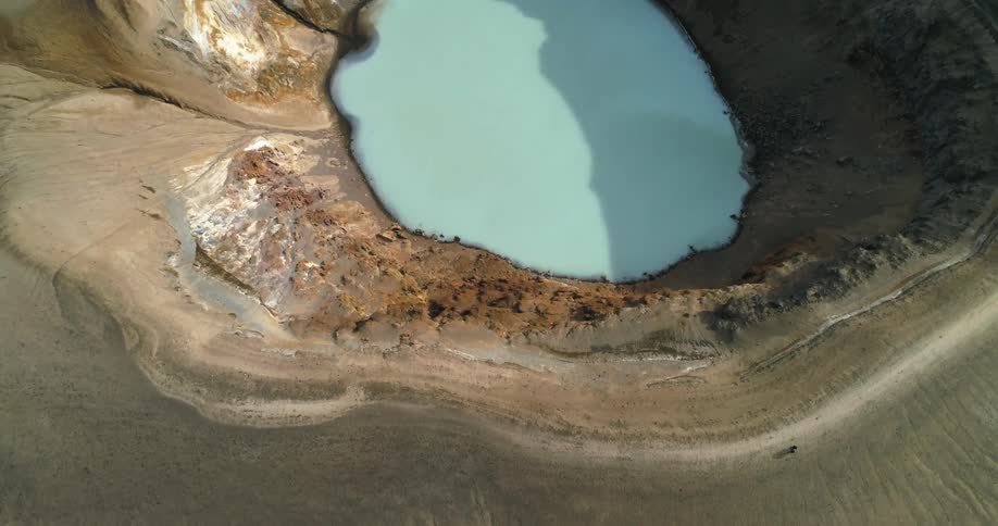 An aerial view of a lake in a crater on a mountain