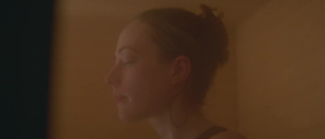A distraught woman lifts her head and opens her eyes before closing them again