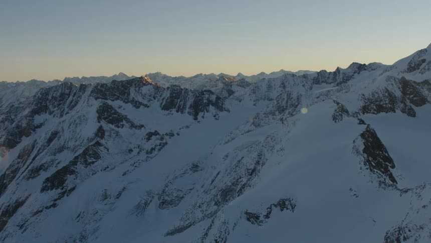 Snow covered mountain ridge with peaks high in a clear sky