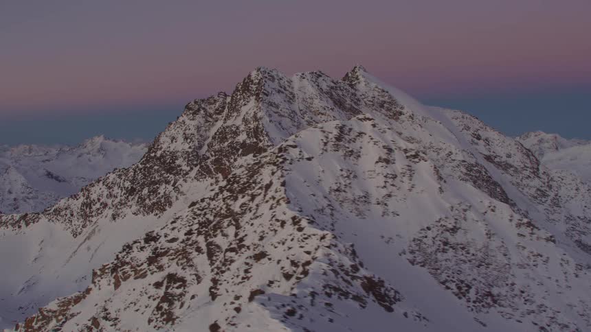 Snow covered mountains under red tinted clouds