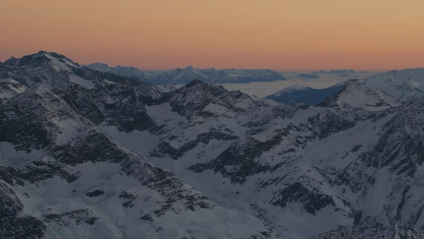 Snow covered mountain range under red sky