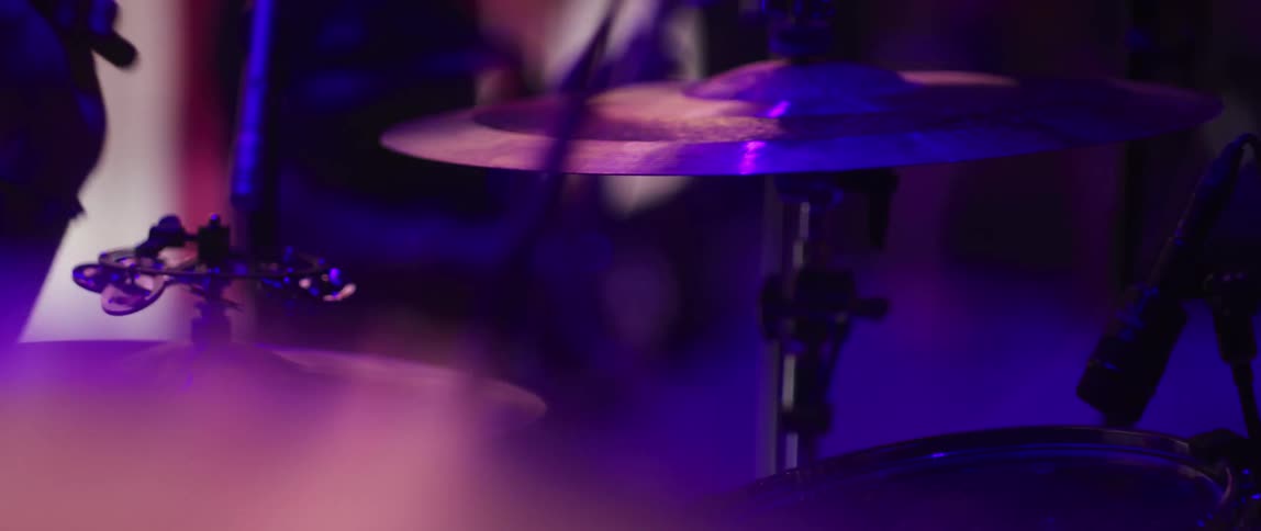 A person playing drums and hitting cymbals