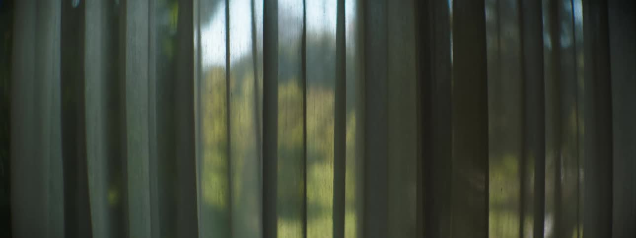 Gray curtain hangs across window in room