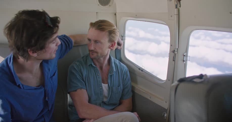 Two men in a plane looking out a window