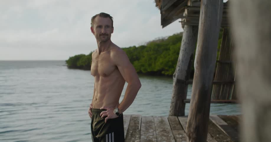 A man standing out on a pier overlooking water