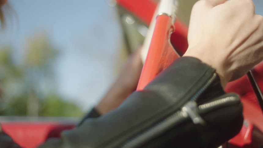 A woman is turning the wheel and driving her car