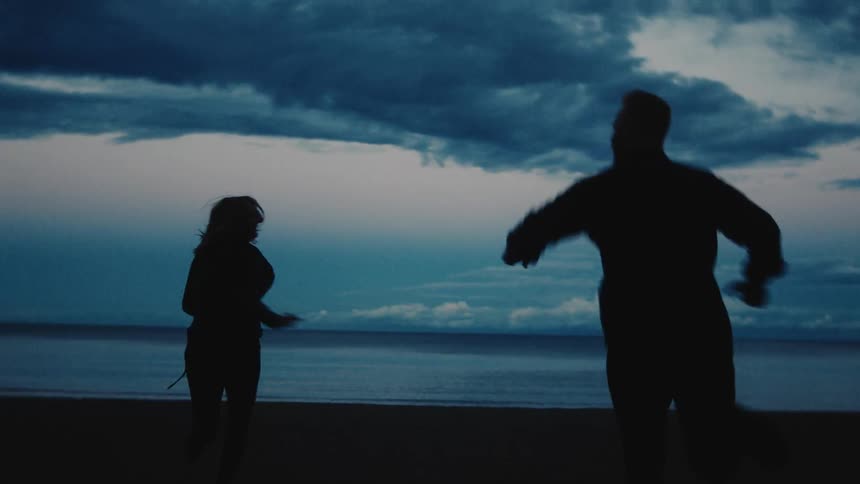 A man and woman running outside