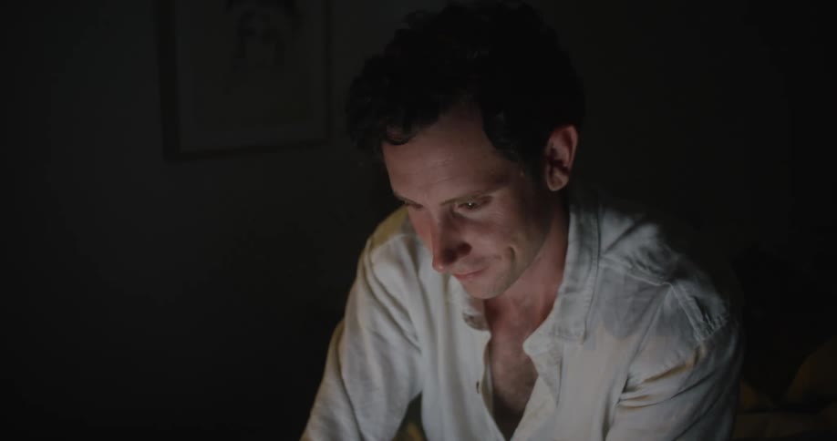 A man sitting in a room typing on a laptop
