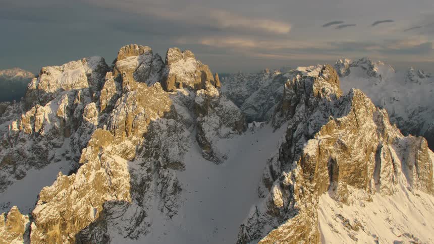 Snow fills in the valley between mountain peaks