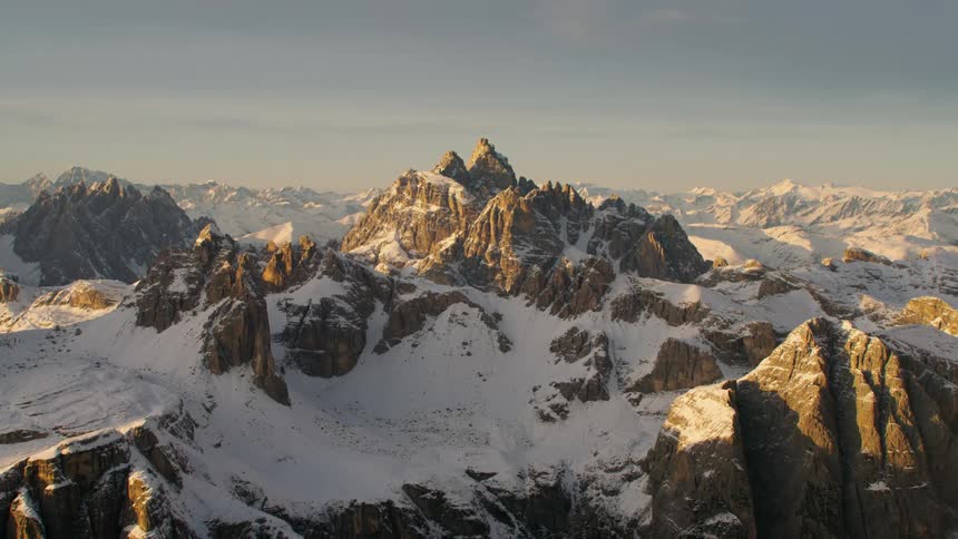 Snow covered mountains stand partly in shadow