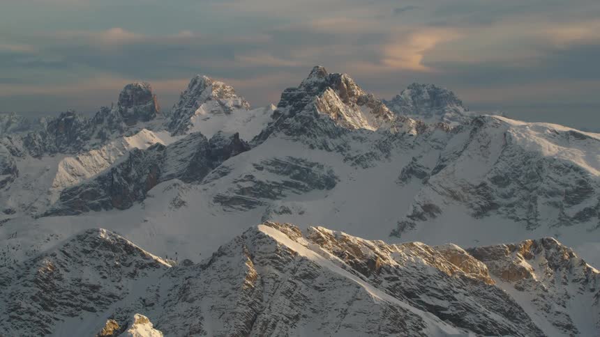 Snow covered mountains with peaks high in a cloudy sky