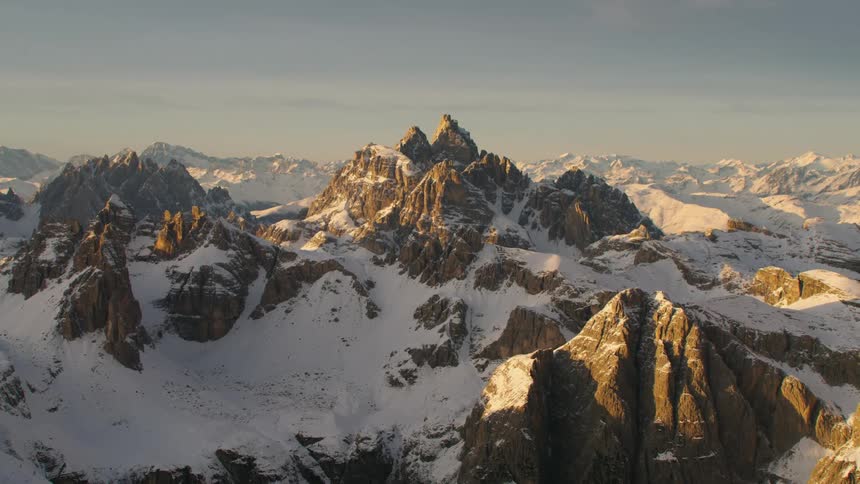 An aerial view of a mountain range with snow on it