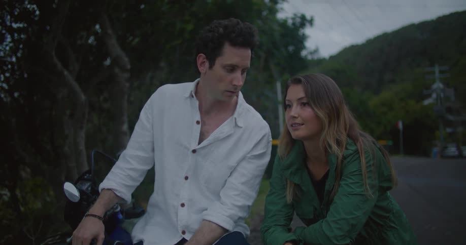 A man and woman talk and laugh on the road