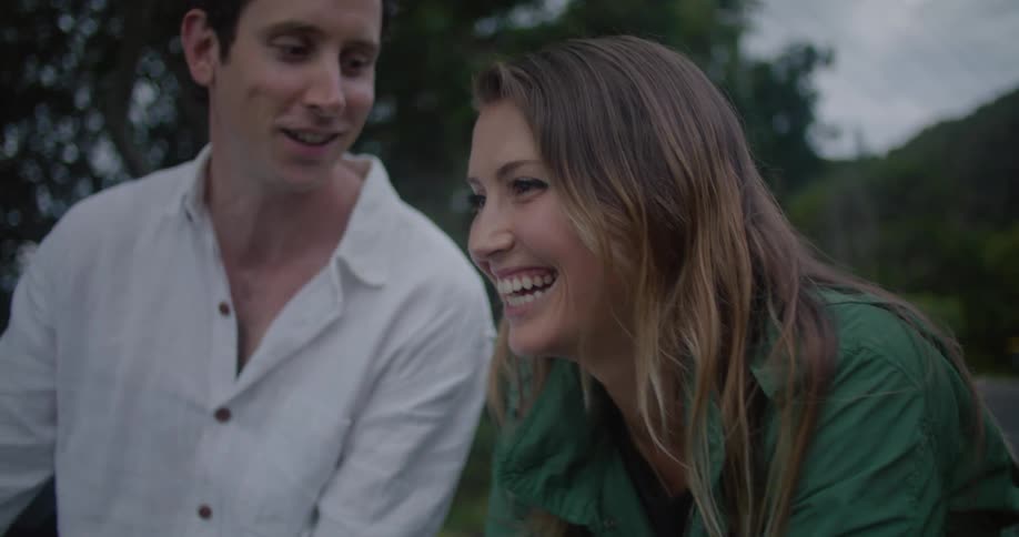 A man and woman sitting outside talking and laughing