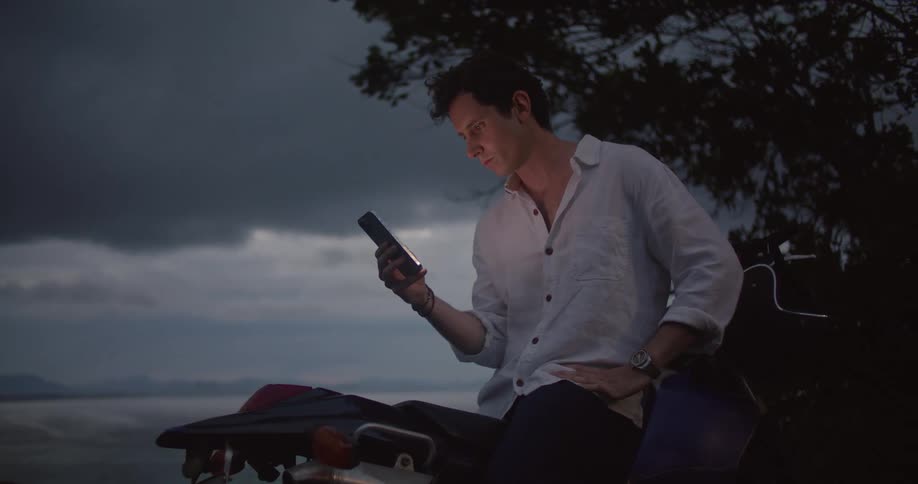 A man sitting outside using a smartphone