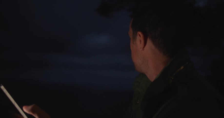 A man sitting outside using a smartphone