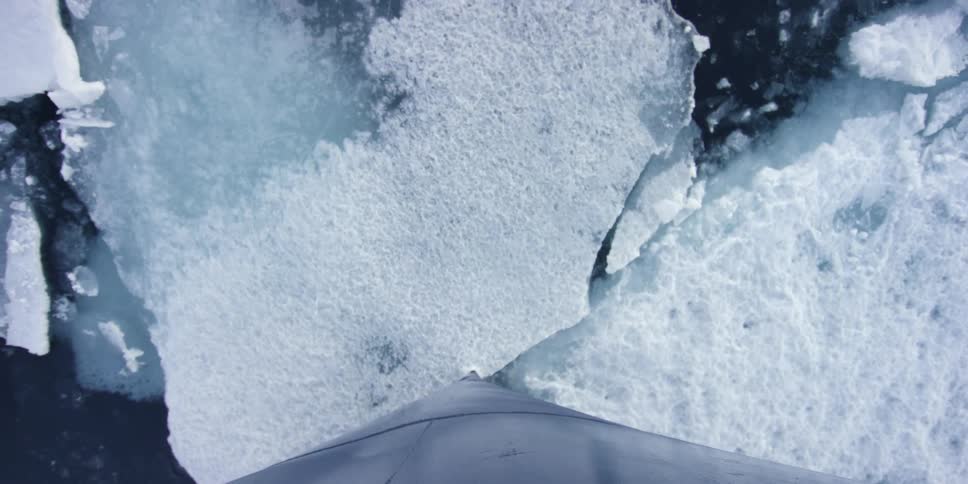 A boat cuts through some ice