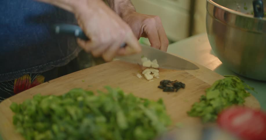 A person is cutting vegetables in the kitchen