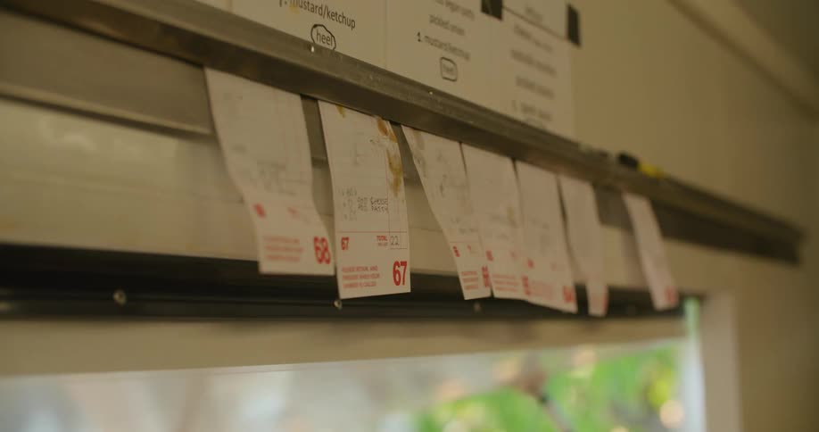 A person hangs order tags in the food truck