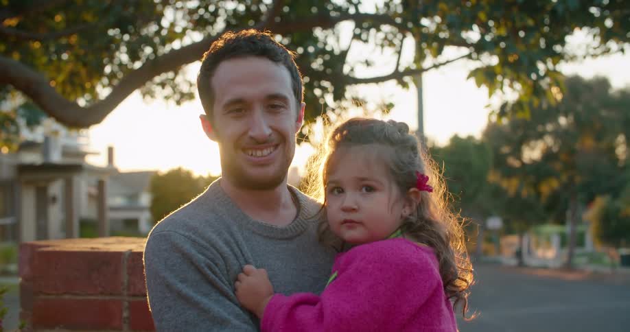 A father holding his daughter outdoors