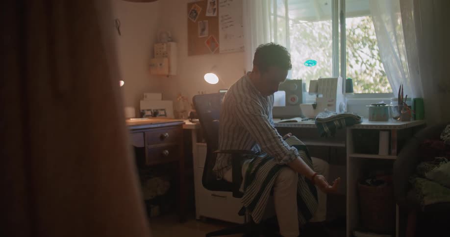 A man is measuring a sheet of fabric in his office