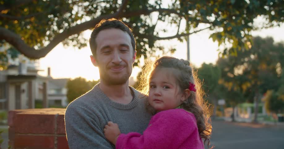 A man is posing holding his daughter