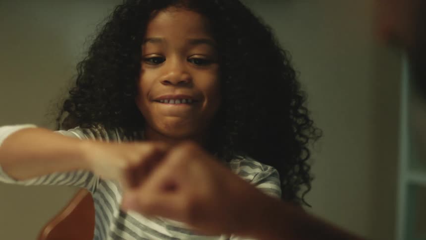 A girl laughs as she fist bumps her father