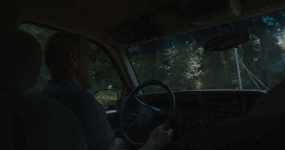 A man drives a car down the street