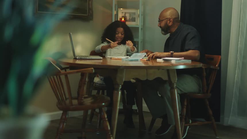 A father helps his child with homework