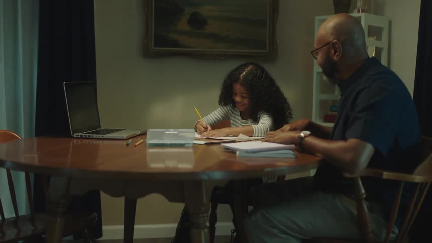 A father is helping his child with homework