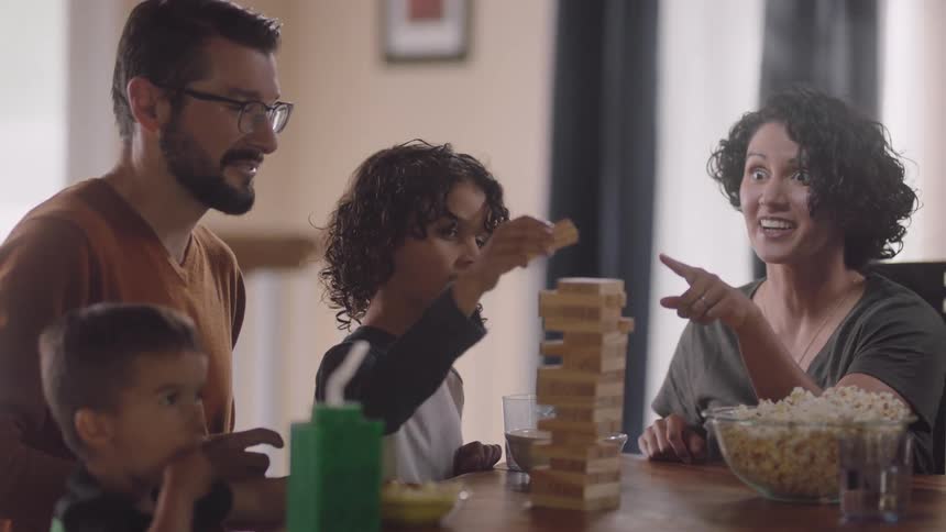 A family is playing a board game at home