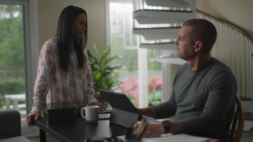 A woman is standing at the desk talking to a man