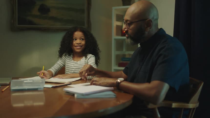 A father helps his daughter do homework