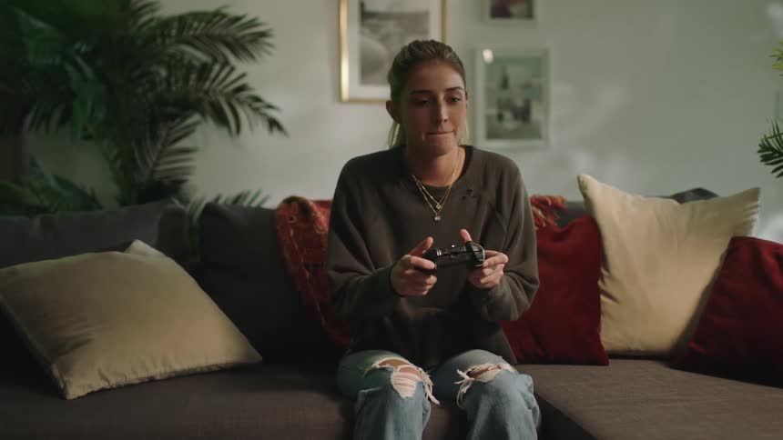 A woman is playing video games at home