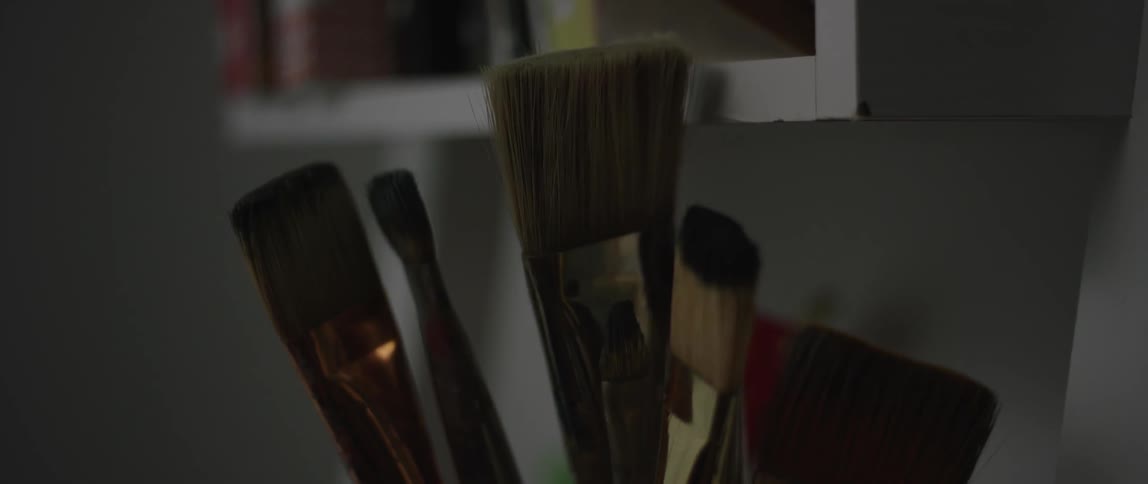 Some paint brushes in a dim room